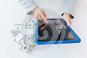 Close up of woman hands with tablet pc and money