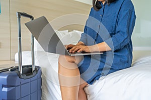 Close up of woman hands typing laptop computer on bed
