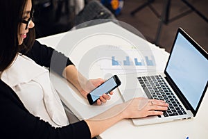 Close Up of woman hands using mobile phone and laptop computer with blank copy space screen for your advertising text