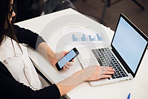 Close Up of woman hands using mobile phone and laptop computer with blank copy space screen for your advertising text