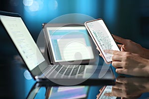 Woman hand using multiple devices at home in the night photo