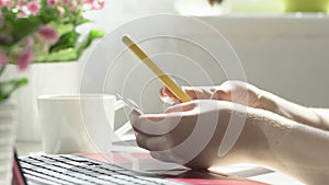 Close up woman hands using smartphone and computer laptop at workplace or work from home