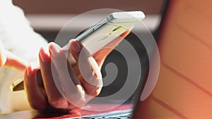 Close up woman hands using smartphone and computer laptop at workplace or work from home