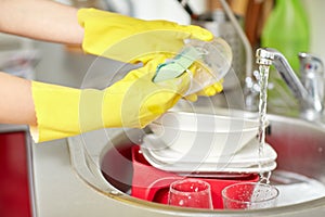 Close up of woman hands washing dishes in kitchen photo
