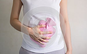 Close up woman has abdominal pain, woman`s belly with hot water bottle,
