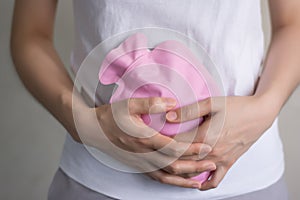 Close up woman has abdominal pain, woman`s belly with hot water bottle,Close up woman use Hot Pack