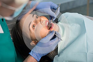 Pohľad zblízka na žena s zubná skontrolovať hore v zubná klinika. skúmanie pacienti zuby zubná nástroje 