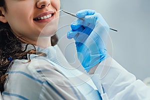 Close up of woman having dental check up in dental office. Dentist examining a patient`s teeth with dental tools. Dentistry