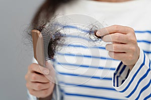 close up woman having hair loss problem with hairbrush