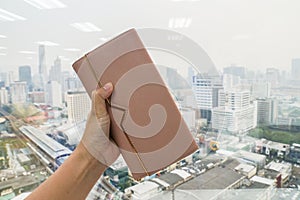 Close up woman hold cute leather wallet in left hand with city view