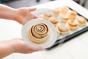 Close up of a woman holding a baked sweet roll