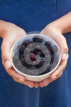 Close Up Of Woman Holding Bowl Of Blackberries