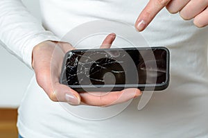 Close up of woman holding broken mobile phone