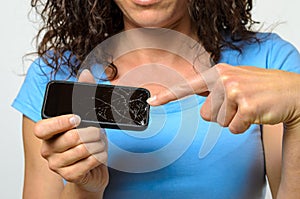 Close up of woman holding broken mobile phone