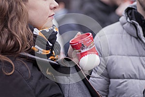 Close-up of woman holding glass cup of delicious white mulled wine in her hands.A girl holds a cup of mulled wine in her hands.