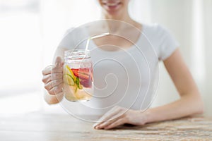 Close up of woman holding glass with fruit water