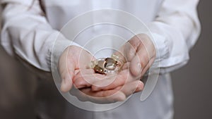 Close up of woman holding hearing aid equipment. The hearing aid lies in the female palm. Hearing aid concept. Woman