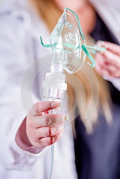 Close up of woman holding in her hands a nebulizer for asthma and respiratory diseases at home