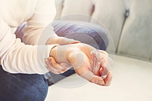 Close up Woman holding her wrist, pain concept.