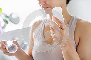 Close up woman holding natural crystal alum deodorant in modern bathroom. Eco friendly natural beauty and hygiene