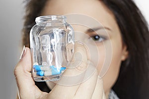 Close up of woman holding pill container