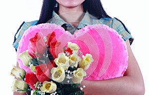 Close up woman holding pink heart and flowers