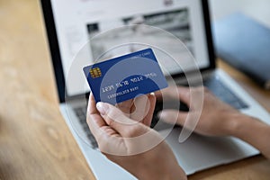Close up woman holding plastic credit card, paying online