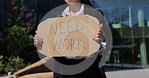 Close up woman holding poster cardboard with need job jobless message. Global unemployment.