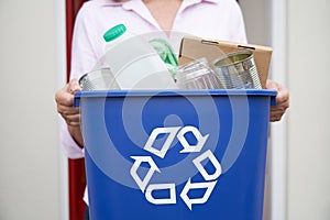 Close Up Of Woman Holding Recycling Bin Of Reusable Waste Outside Front Door