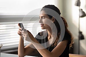 Close up woman holding smartphone, looking at screen, chatting