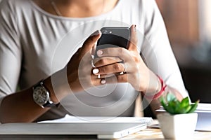 Close up woman holding smartphone, typing message