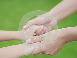 Close up of woman holds the hand of a lovely child.