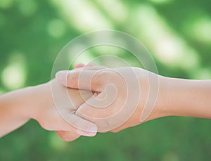 Close up of woman holds the hand of a lovely child.