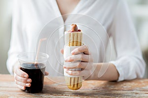 Close up of woman with hot dog and coca cola drink