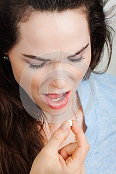 Close-up of a woman with illness taking pill photo