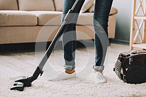 Close up. Woman Cleans Carpet with Vacuum Cleaner.