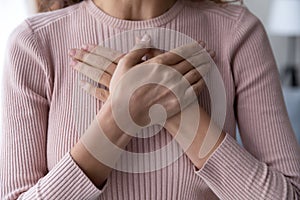 Close up of woman keep hands at chest show gratitude photo
