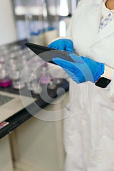 Close-up of Woman in Lab Coat Using Tablet in Lab