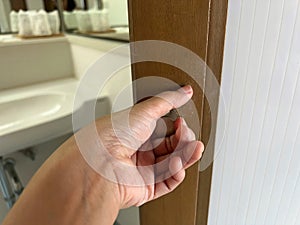 Close up woman left hand pull vintage door knob to enter bathroom for shower