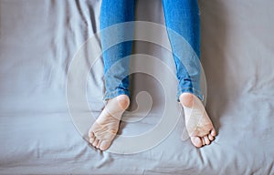 Close up of woman legs with blue jeans,Feet and stretch lazily on the bed