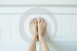 Close Up Woman Legs and Feet with Nail Pedicure looking up, Raised Straight Up. Barefeet in Bedroom Background