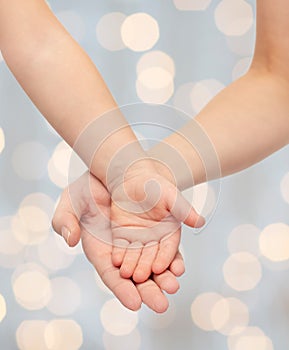 Close up of woman and little child hands together