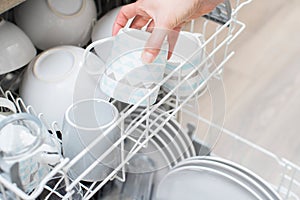 Vista ravvicinata di una donna caricamento piatti lavastoviglie 
