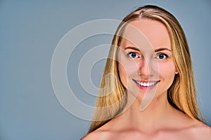 Close up woman with long blonde straight hair looks at the camera. Beauty concept