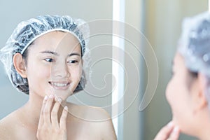 Close up woman looking her face in the mirror with smiling after bath, health care and beauty