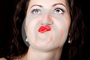 Close-up woman looks straight into the camera on a black background. expresses different emotions, sending a kiss