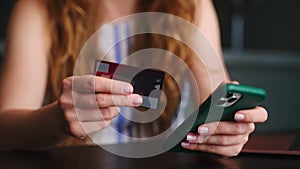 Close up of woman making purchase, payment in fintech application on smartphone and shows thumb up sign with hand