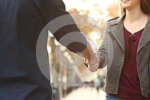 Close up of a woman and man handshking in the street