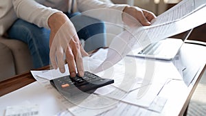 Close up of woman manage home finances calculating on machine