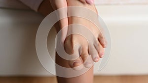 Close up of woman massaging her tired feet. Leg health and body care concept.